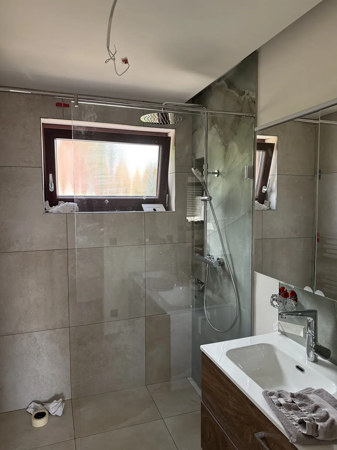 Modernes Badezimmer mit bodengleicher Dusche und Regendusche